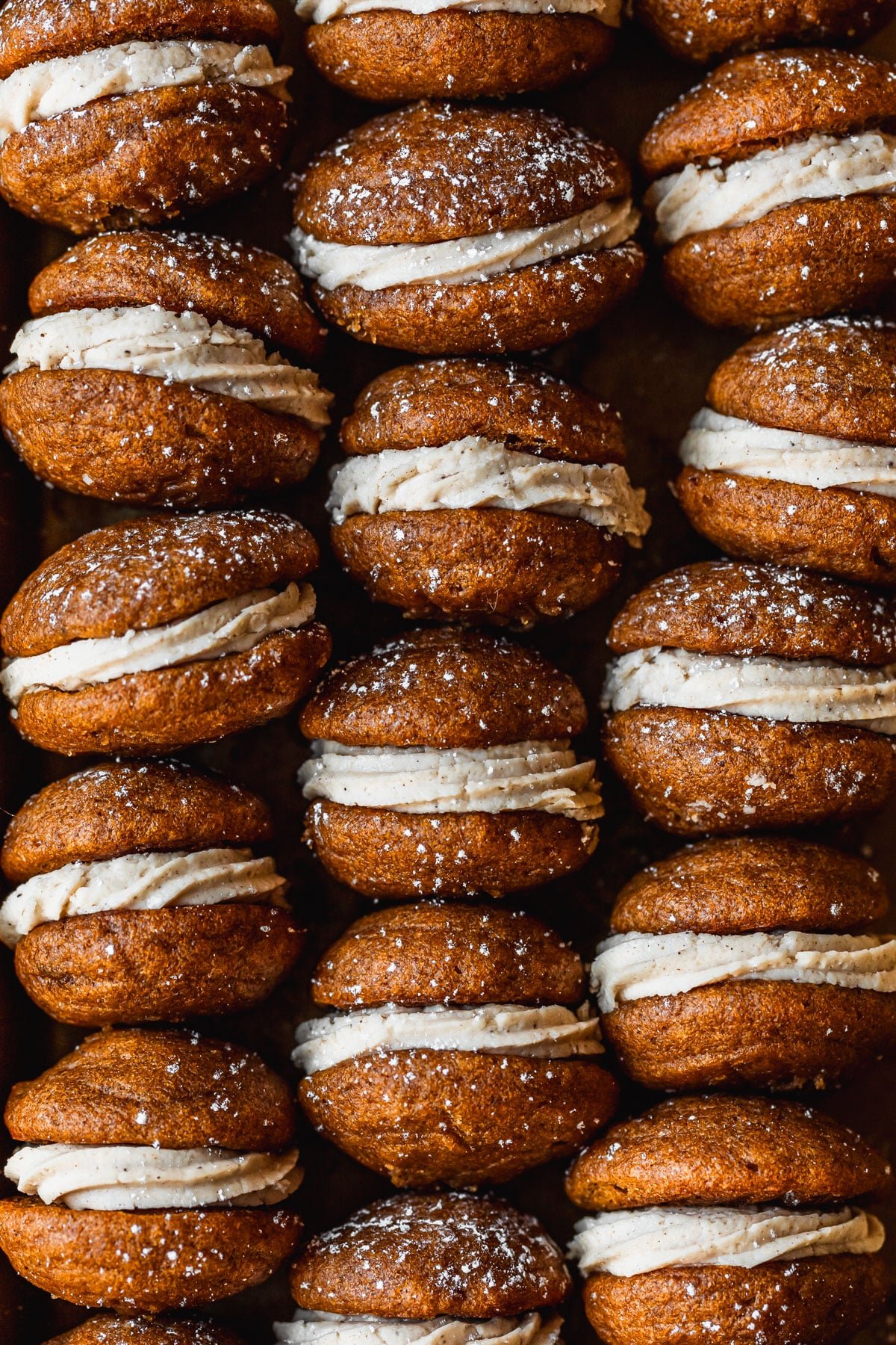 Rows of mini pumpkin whoopie pies with masala chai buttercream.