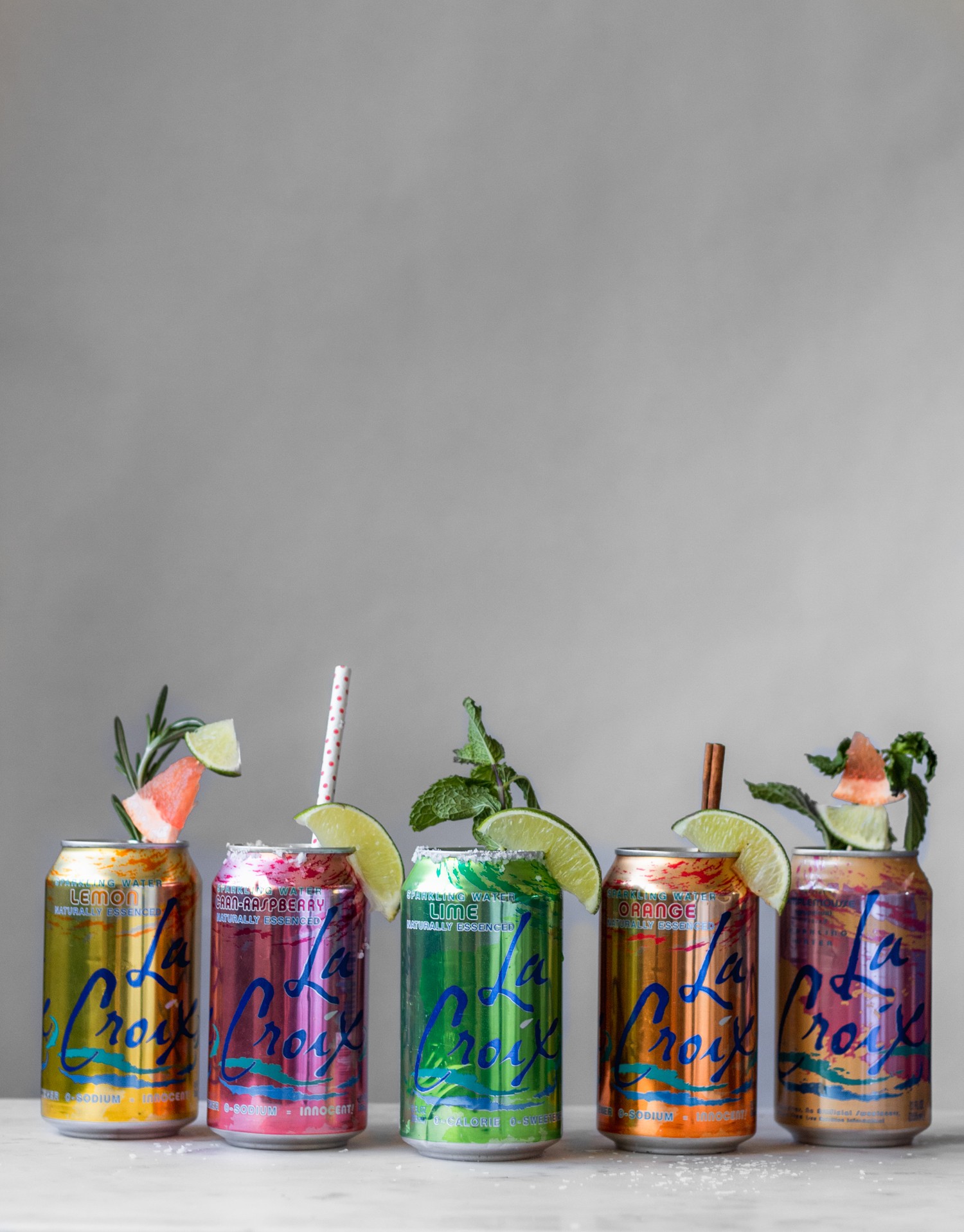 A side image of five cocktails in a can on a marble counter.