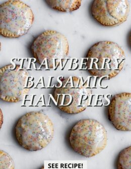Rows of strawberry balsamic hand pies on a marble counter.
