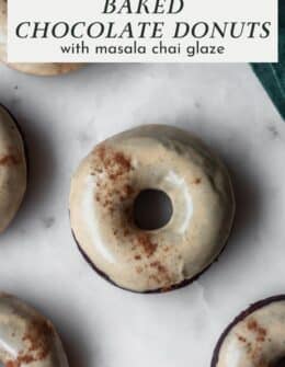 Chai baked chocolate donuts on a marble counter.