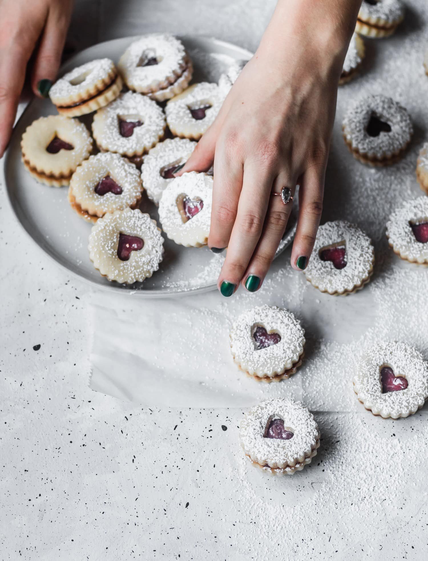 A woman's hand with an engagement ring grabbing a cookie.