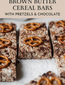 A closeup side image of brown butter Rice Krispie treats with pretzels and chocolate on parchment paper.