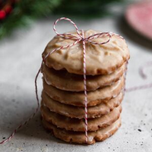 A side image of a stack of cookies on a grey table with garland in the background.