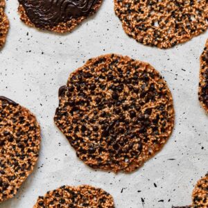 An overhead close up picture of sesame lace cookies with chocolate.