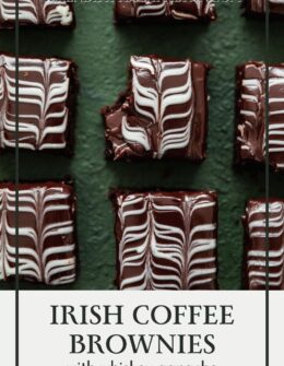 An overhead image of rows of Irish coffee brownies with chocolate and white chocolate swirl ganache on a dark green table.