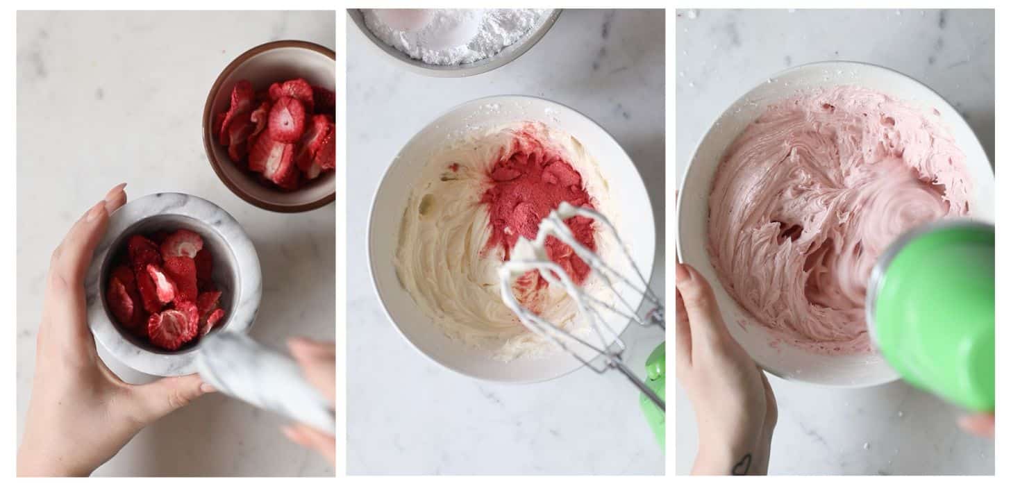 Three images making strawberry buttercream; in photo 1, two hands crush freeze-dried strawberries in a mortar and pestle on a marble counter next to a white bowl of strawberries. In photo 2, a white bowl has buttercream and strawberry powder on a marble counter In photo 3, two hands mix the strawberry buttercream with a green mixer.