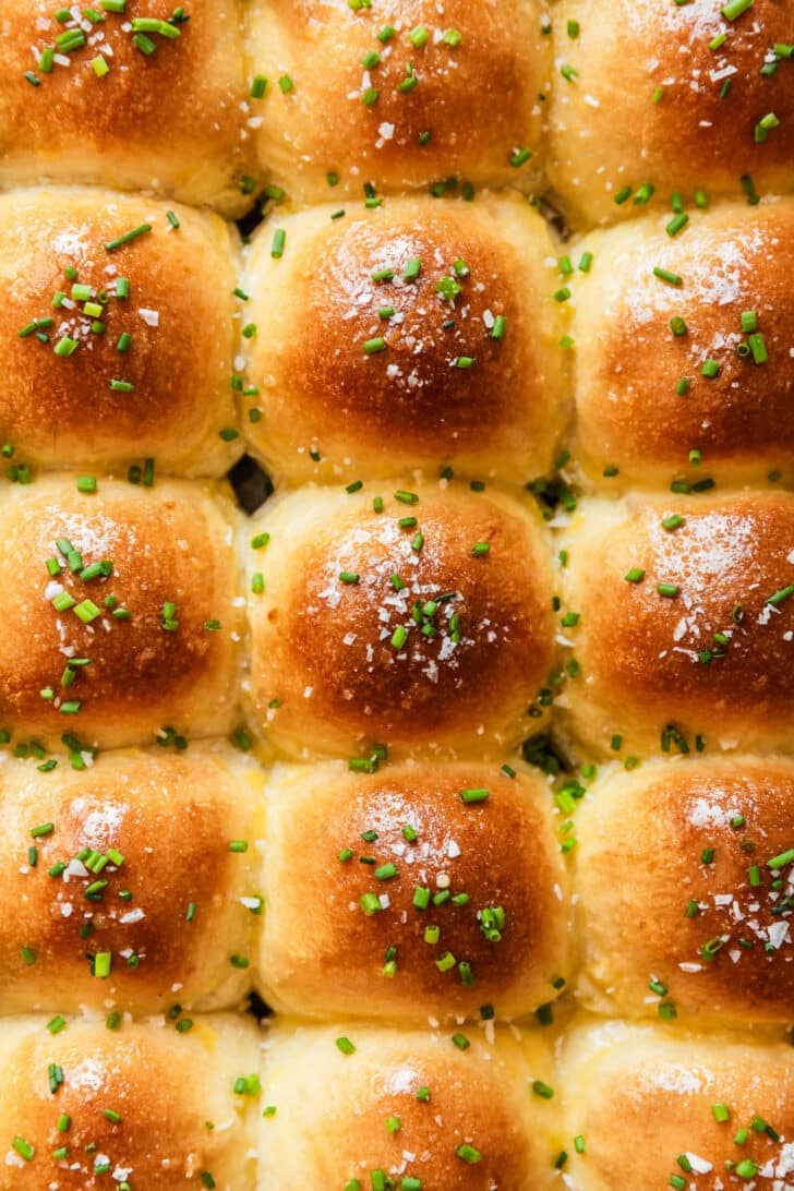 Garlic butter dinner rolls with chives and flaky salt.