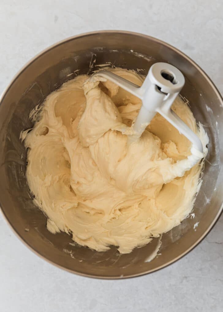 A silver bowl of whipped cream cheese on a marble counter.