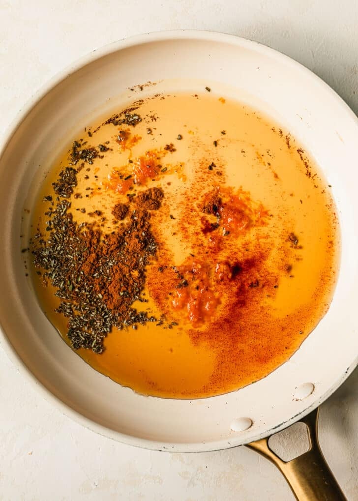 A white pan of maple syrup and spices on a white counter.