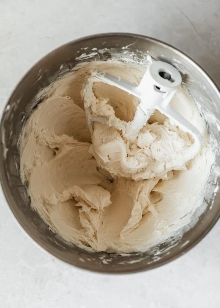 A silver bowl with whipped cream cheese and sugar.