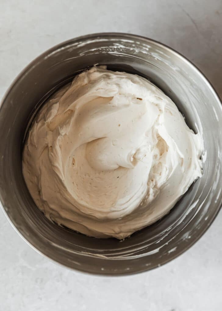 A silver bowl with filling for mini no-bake cheesecakes.