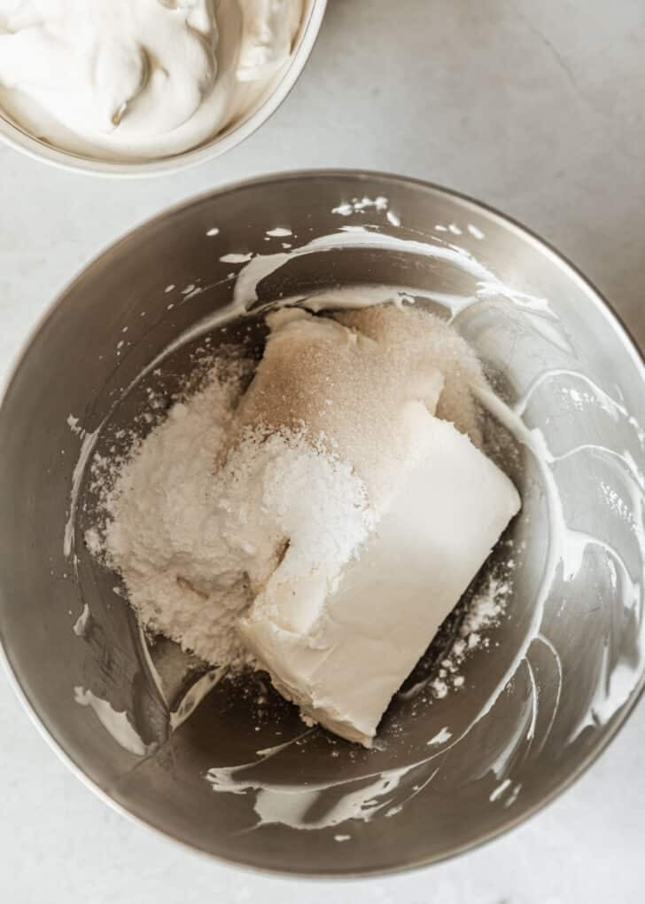 A silver bowl with cream cheese, sugar, and powdered sugar.