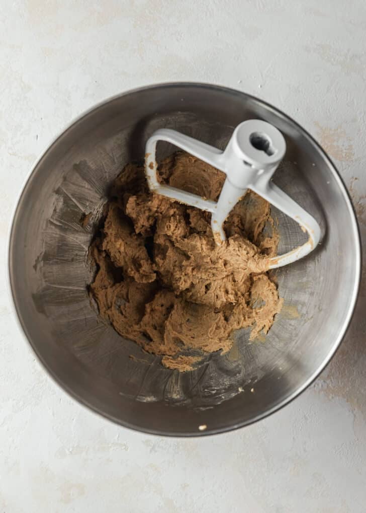 A silver bowl with whipped butter and brown sugar on a tan counter.