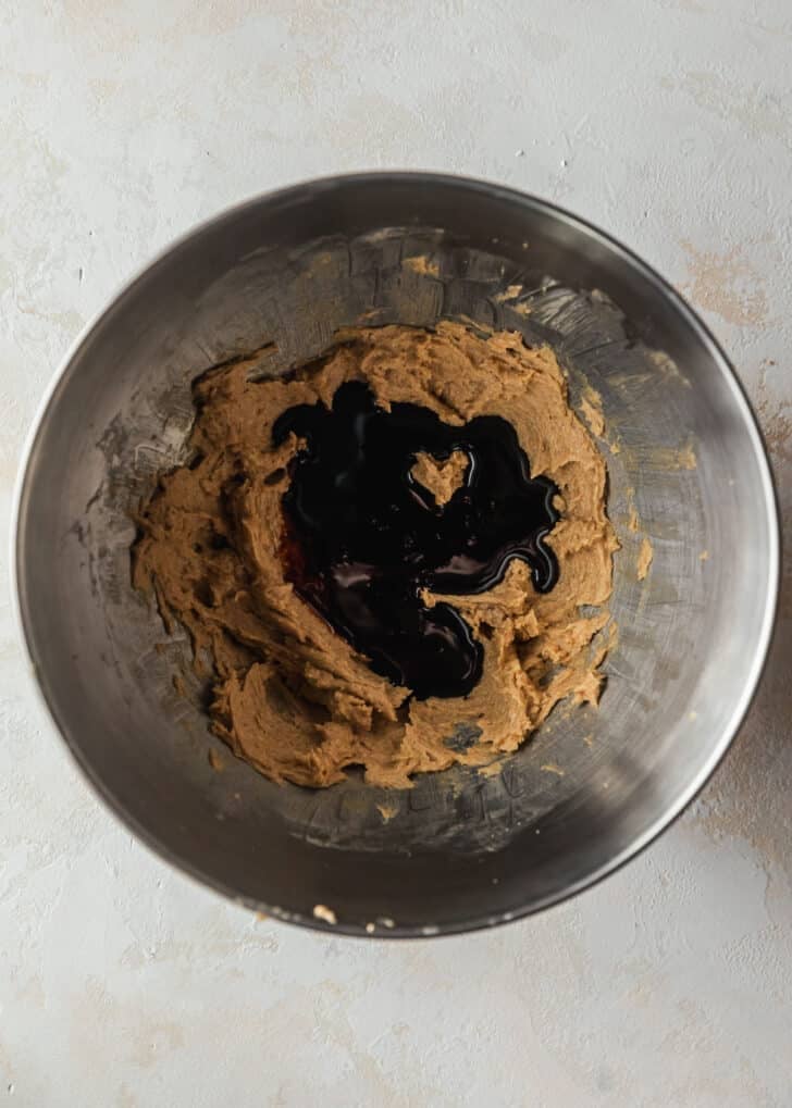 A silver bowl with butter, brown sugar, and molasses on a tan counter.