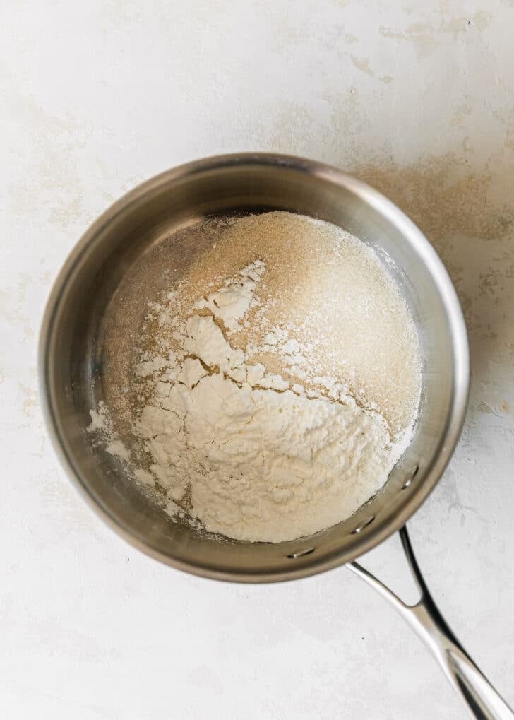 A silver pot of sugar and cornstarch on a tan counter.