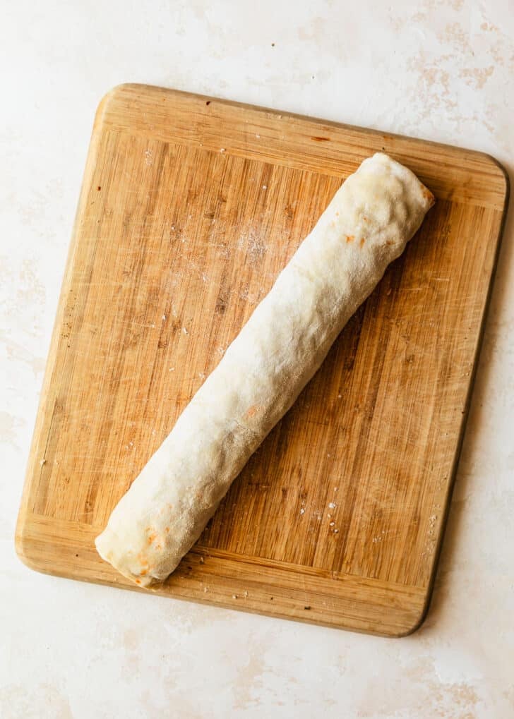 Rolled puff pastry on a wood board.