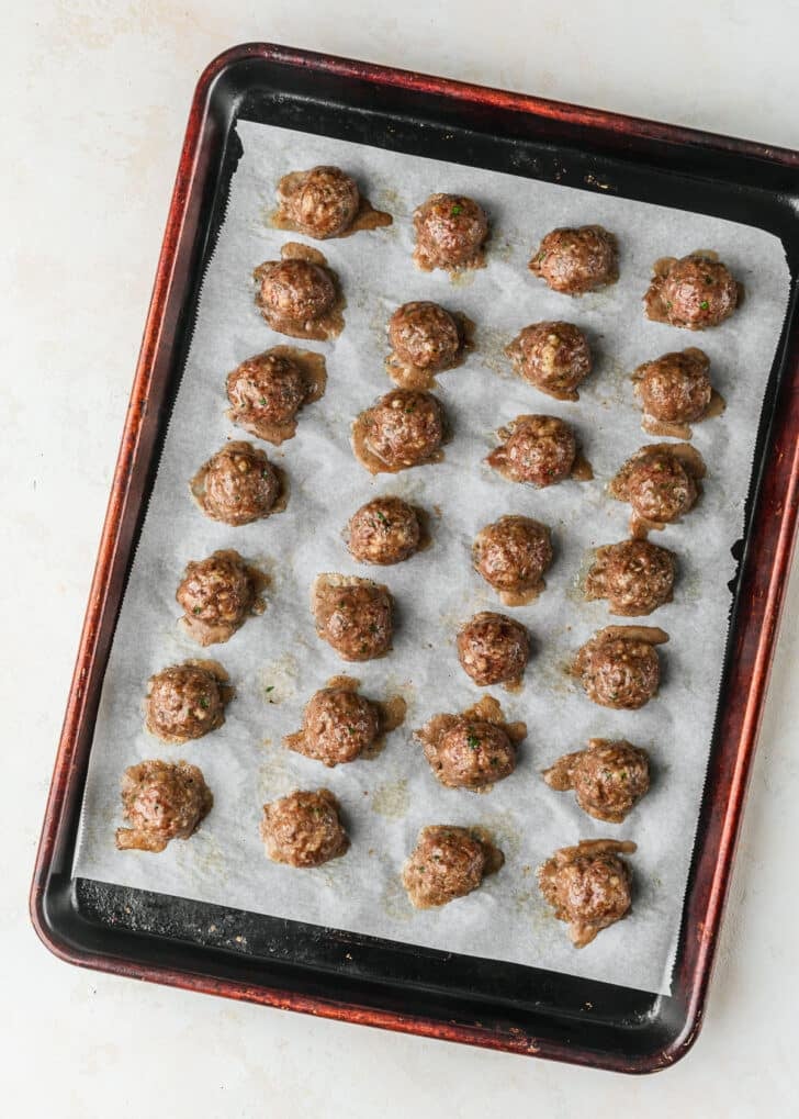 A sheet pan of cooked Italian meatballs for sliders.