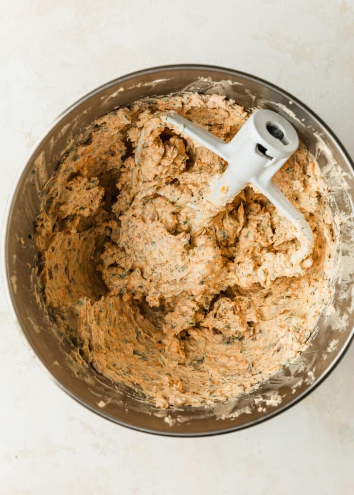 Cheese mixture in a silver bowl on a tan counter.