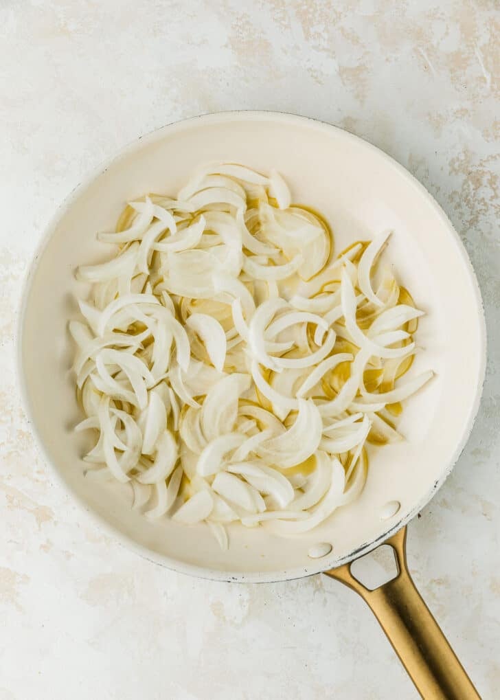 A white pan of onions on a beige counter.
