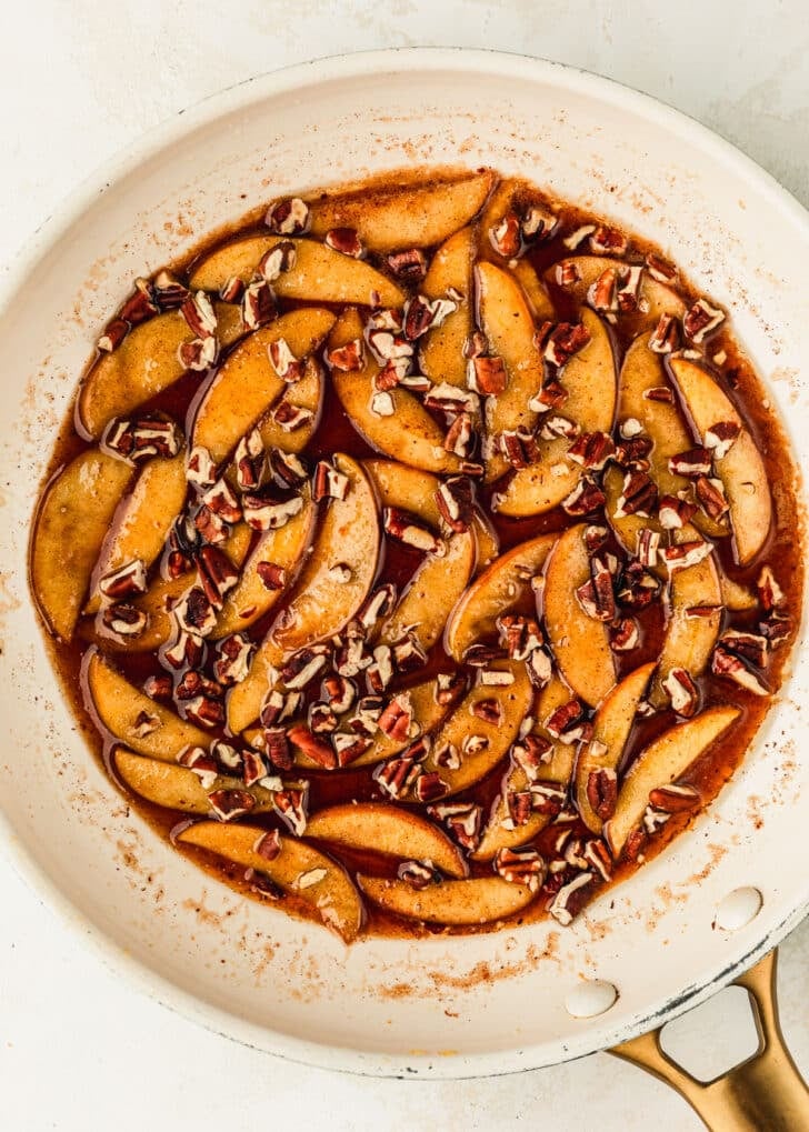 A white pan of caramel apple topping on a beige counter.