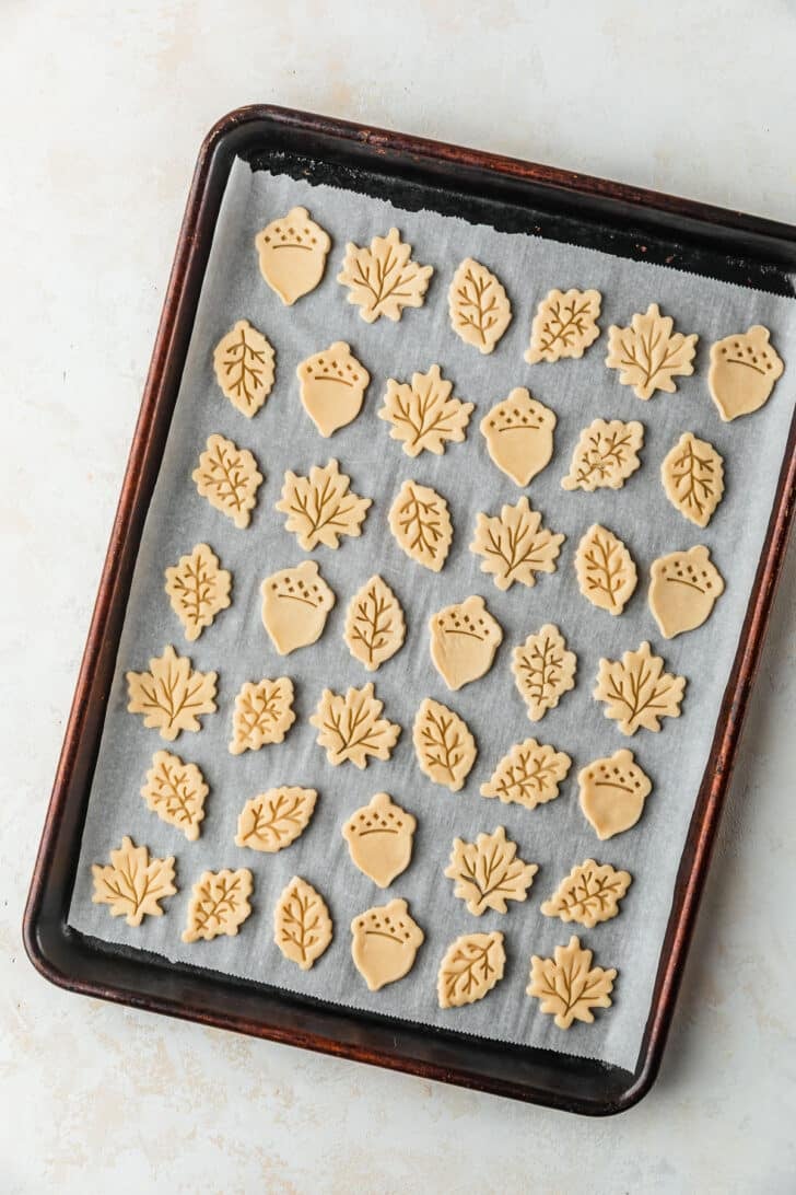 A pan of pie crust leaves on a tan counter.