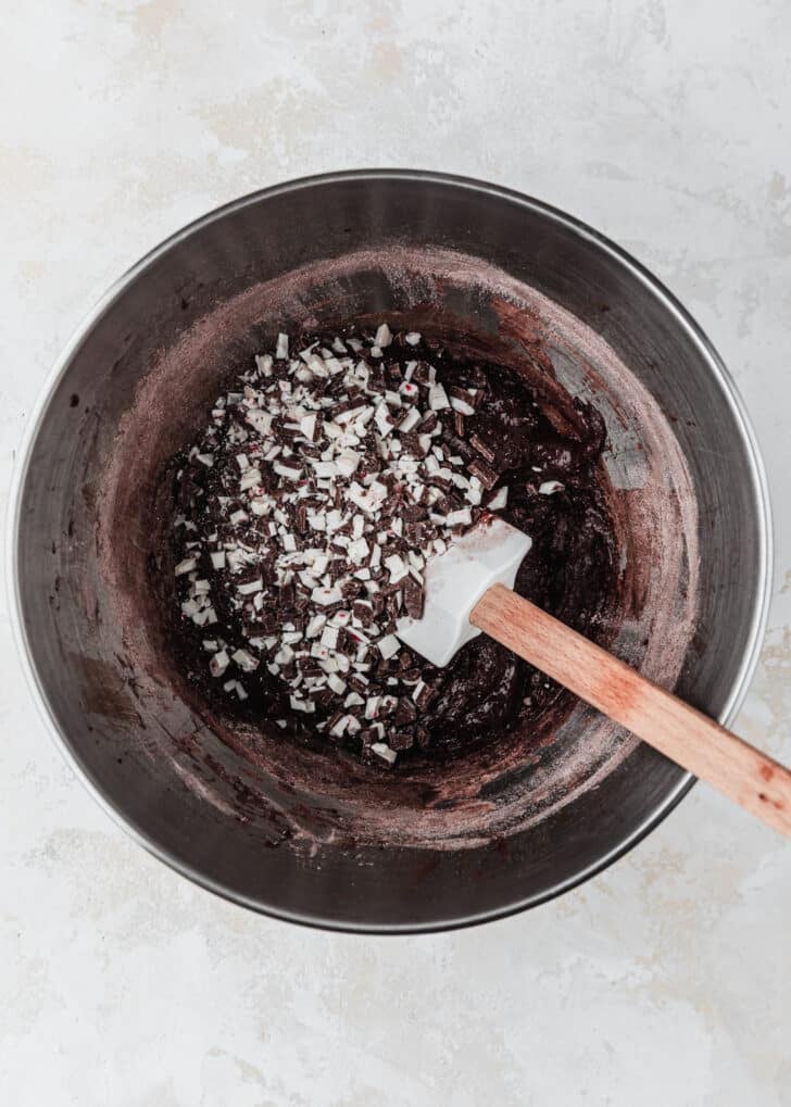 A silver bowl of dough for mini chocolate peppermint bark cookies.