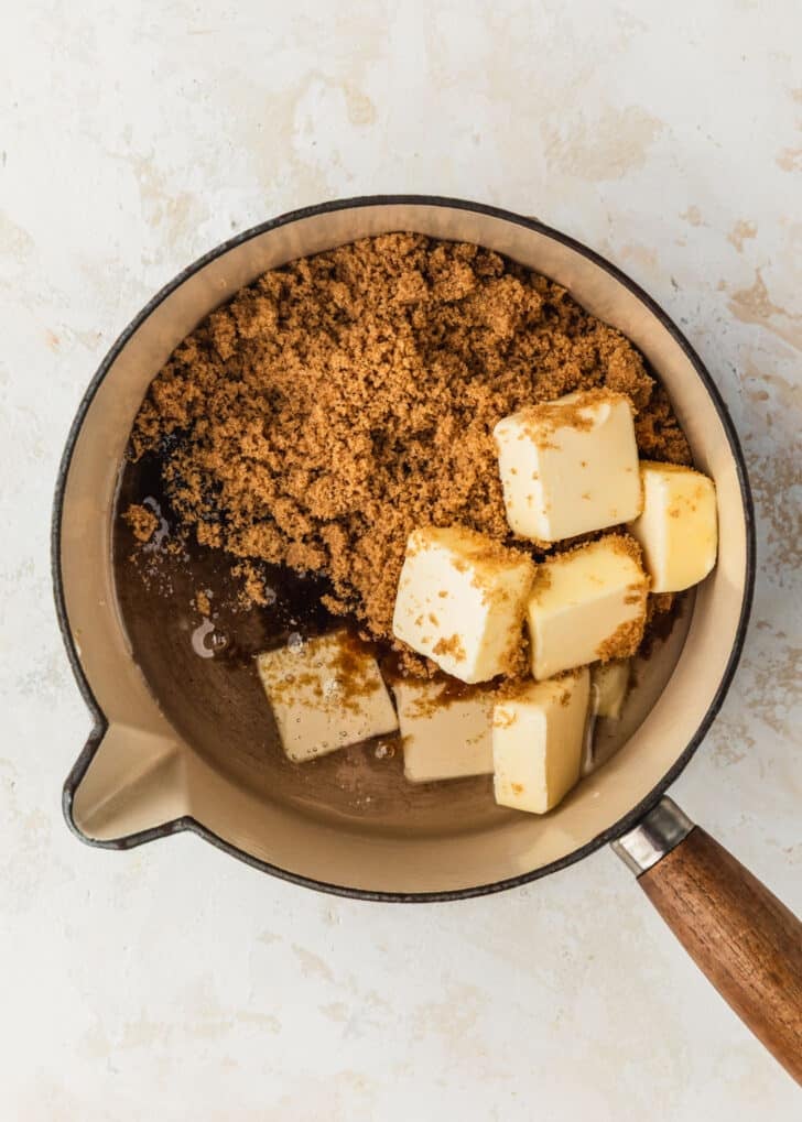 A white pot of brown sugar, butter, and corn syrup on a tan counter.
