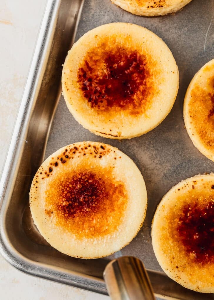 A torch bruleeing mini creme brulee cheesecakes.