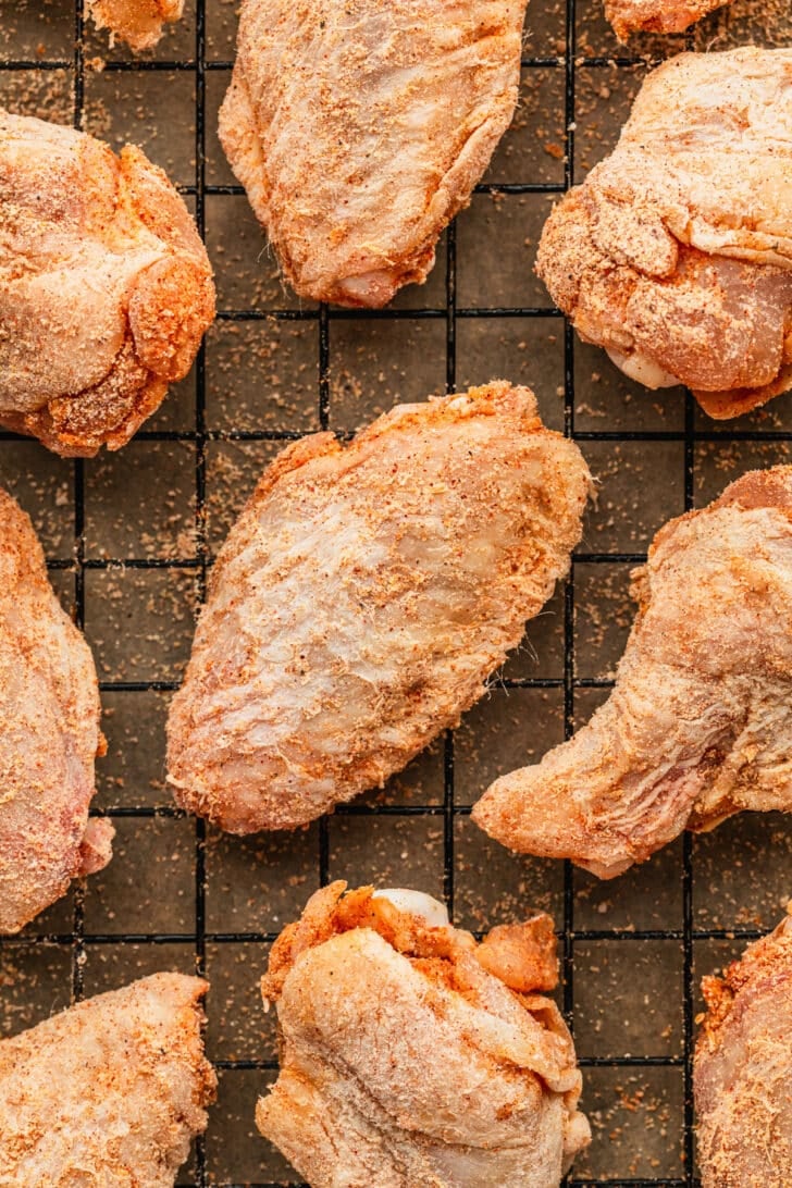 Raw wings on a wire rack.