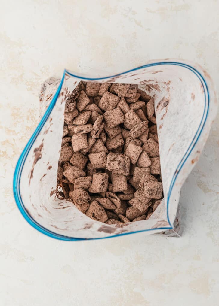 A baggie of Nutella football muddy buddies with powdered sugar and cocoa powder.
