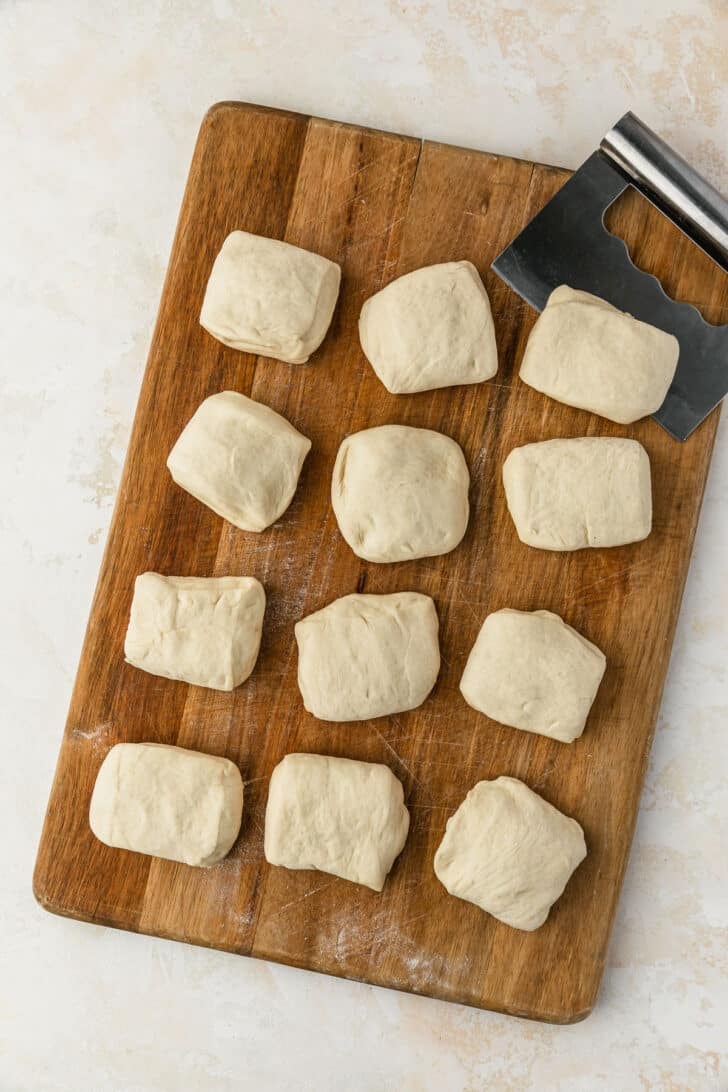 A wood board of pieces of dough.