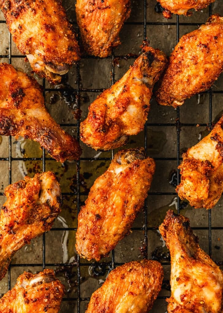 Rows of baked chicken wings on a wire rack.