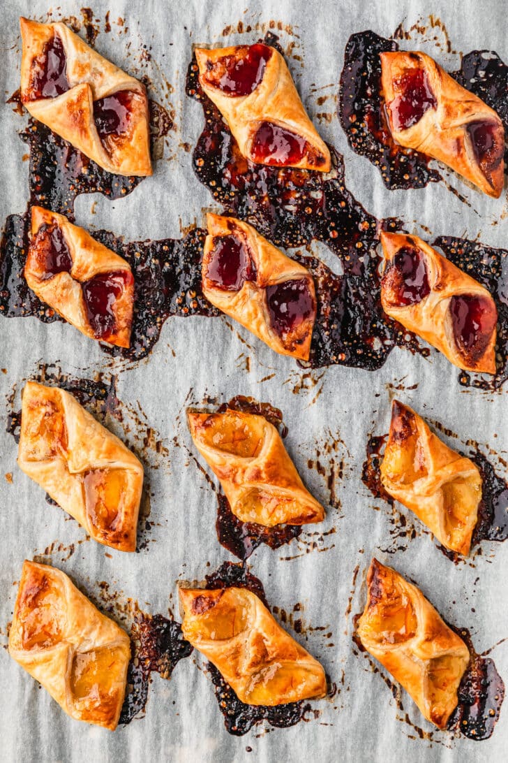 Baked puff pastry jam tarts on parchment paper.