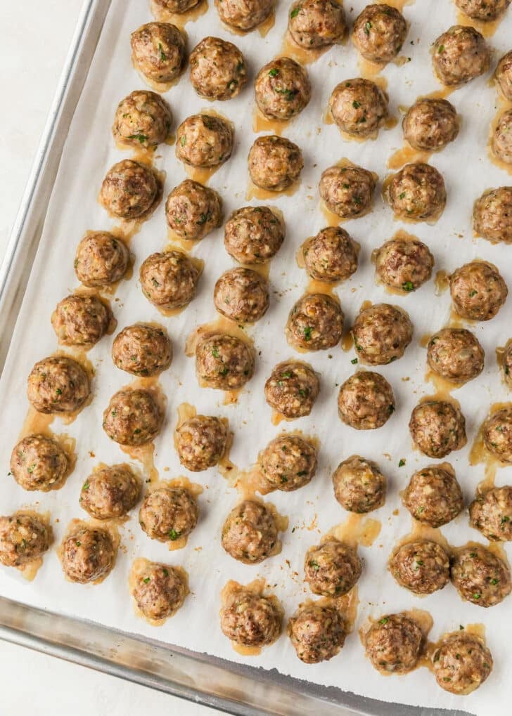A sheet pan of baked Spanish meatballs.