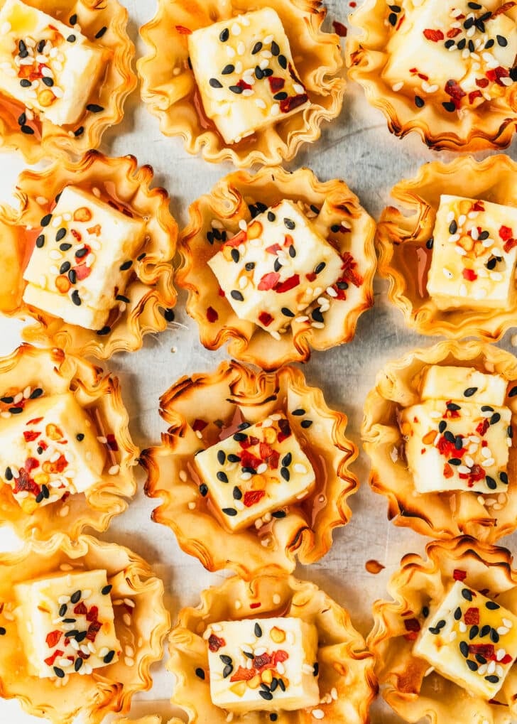 Rows of feta phyllo cups on a silver tray.