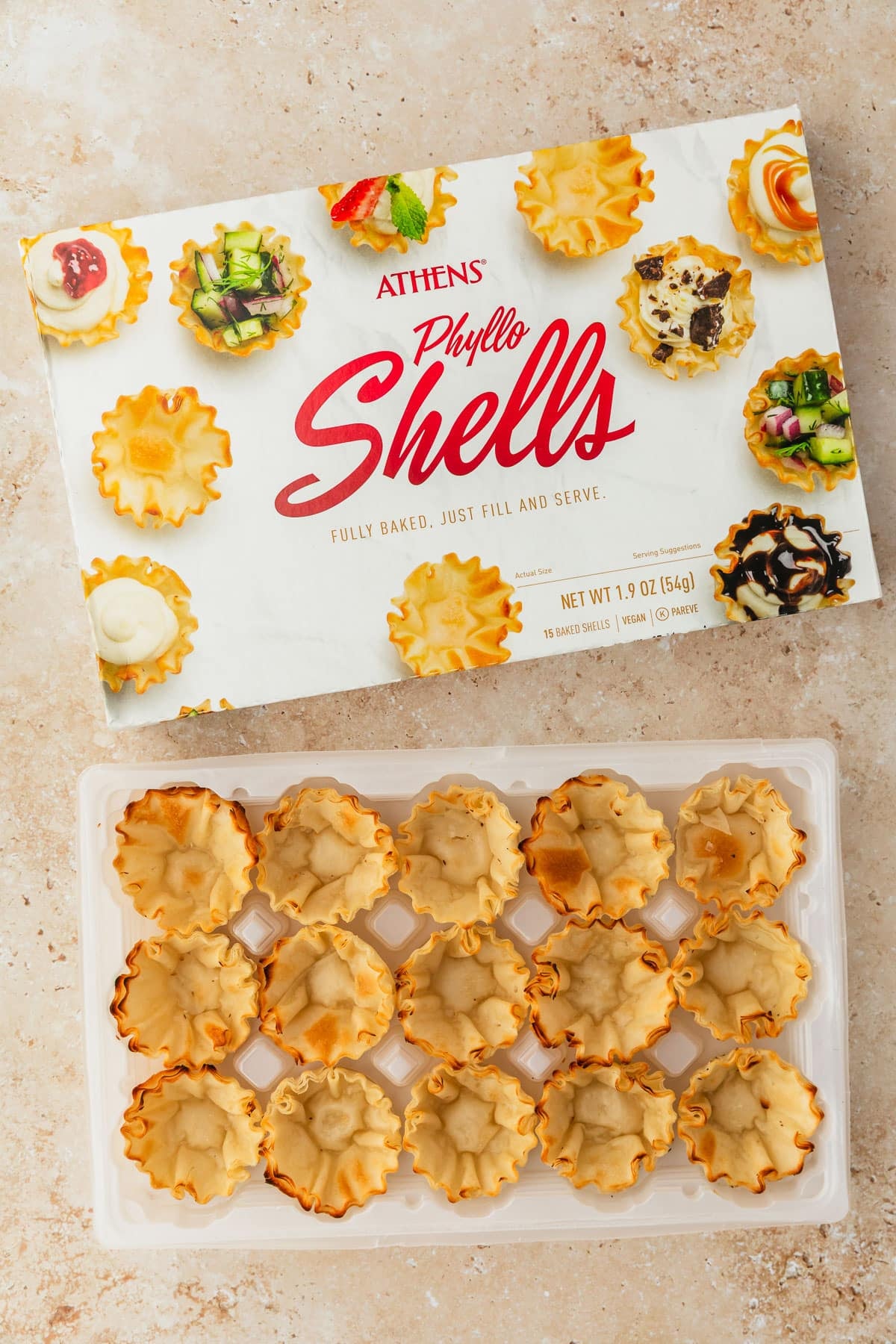 A box and package of phyllo shells on a tan marble counter.