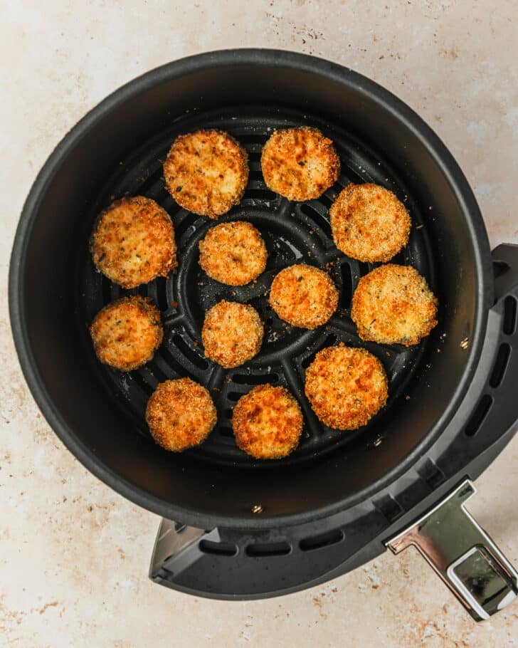 An air fryer with fried zucchini.