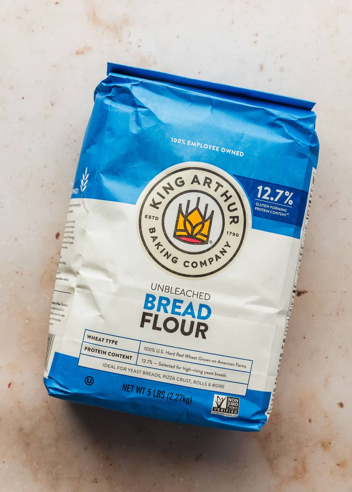 A bag of bread flour on a tan counter.