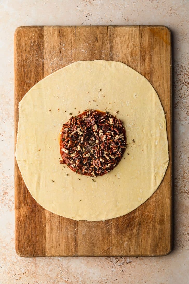 A puff pastry circle with pumpkin butter, candied pecans, and fresh sage.